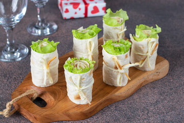 Appetizer from pita bread with ham, cheese and lettuce on wooden board