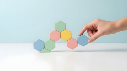 Hand Placing Colorful Hexagonal Blocks for Strategic Growth and Teamwork Concept on Clean Background
