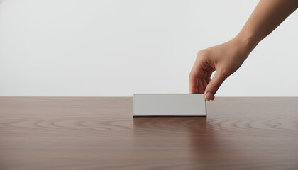 Hand placing Blank Name Plate Mockup on Wooden Desk. Empty Metal Sign Holder for Office Identity, Reservation Card, or Business Presentation Copy Space.