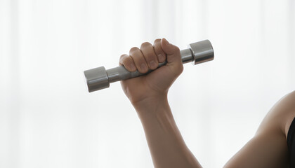 Close-up of Hand Holding Small Metallic Dumbbell in High Key. Strength Training, Fitness, and Home Workout Concept.