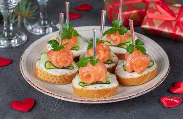 Festive canape with salted salmon, cucumber, soft cheese and parsley