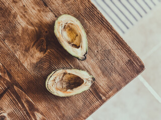 Two halves of an old avocado with brown discolorations