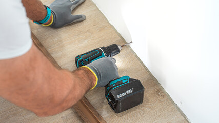 Installing elegant plastic baseboard, showcasing skilled craftsmanship in home improvement and...