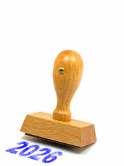 Holzstempel mit dem Aufdruck 2026 vor wei&szlig;em Hintergrund