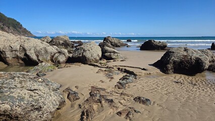 Scenic ocean coastline with rocky beach and clear blue sky. Asturias, Spain. Concha de Artedo beach. Tourism, vacation, travel concept