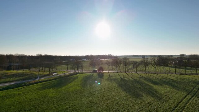 Sunshine Illuminating Peaceful Landscape Scene, Golden Sunlight Casting Shadows Over Lush Green Field