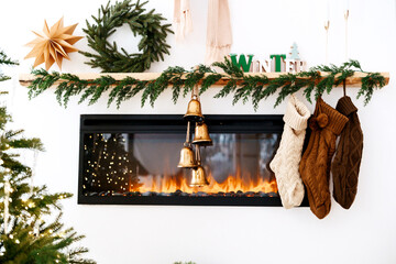 Cozy Christmas fireplace with stockings hanging and warm glowing fire, festive garland and bells