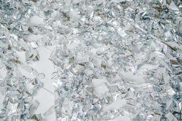 Shiny silver confetti scattered on a white background, abstract texture