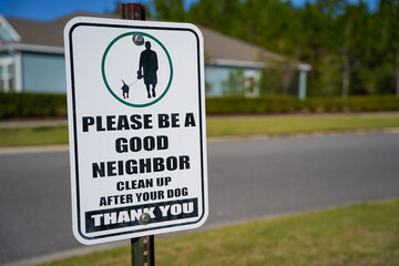 Sign along a sidewalk in a Community Encouraging People to Clean Up After Their Dogs Offset to the Left