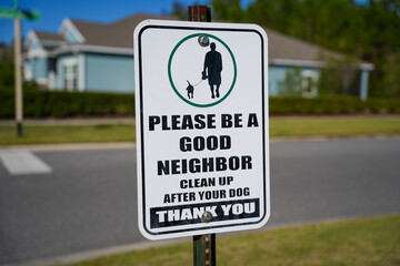 Sign along a sidewalk in a Community Encouraging People to Clean Up After Their Dogs Centered in the Frame