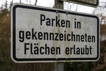 Obraz premium A white traffic sign indicates that parking is allowed in designated areas, guiding drivers and organizing street spaces.