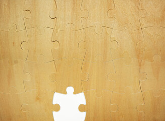 A wooden puzzle shows several interlocking pieces. One piece is missing, leaving an empty space in the center. This scene invites thoughts of completion and challenge.