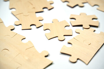 Several unfinished puzzle pieces lie on a plain flat surface in a home. The pieces are arranged in a random pattern, indicating a puzzle activity is in progress.