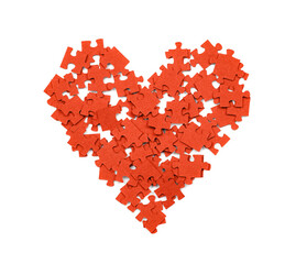 Red puzzle pieces are arranged in the shape of a heart on a white background. This setup shows a creative activity that can be enjoyed individually or in a group.
