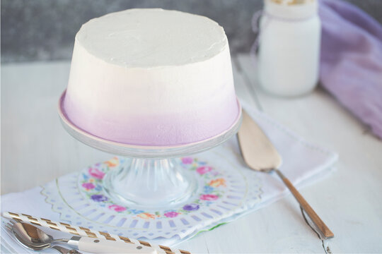 Close-up of an Angel sponge cake with lilac frosting on a cakestand