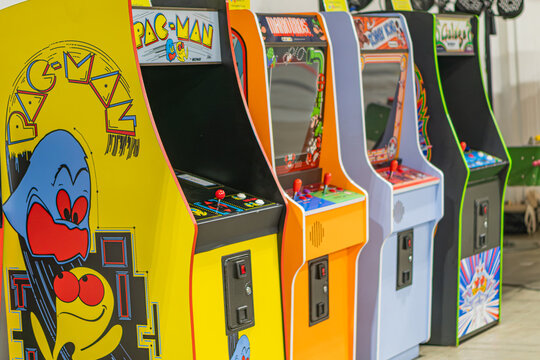 Collection of yellow and orange arcade game consoles lined up against a wall, each with character artwork and control buttons - Kyiv, Ukraine - June 7, 2025