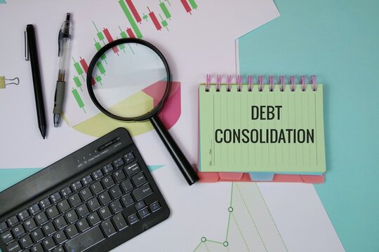 A desk setup featuring a green notebook labeled debt consolidation, a magnifier, charts, and a keyboard, illustrating financial analysis, budgeting, and planning for debt reduction and financial goals - Powered by Adobe