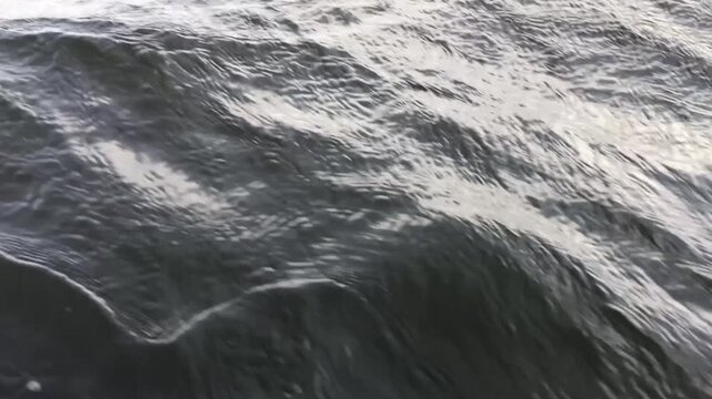 dark rushing water and waves overboard the boat