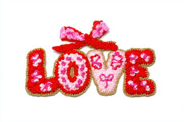 Handcrafted embroidered word &ldquo;LOVE&rdquo; with hearts and a bow isolated on a white background.