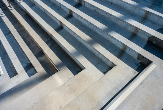 Abstract concrete steps creating geometric shadow pattern.