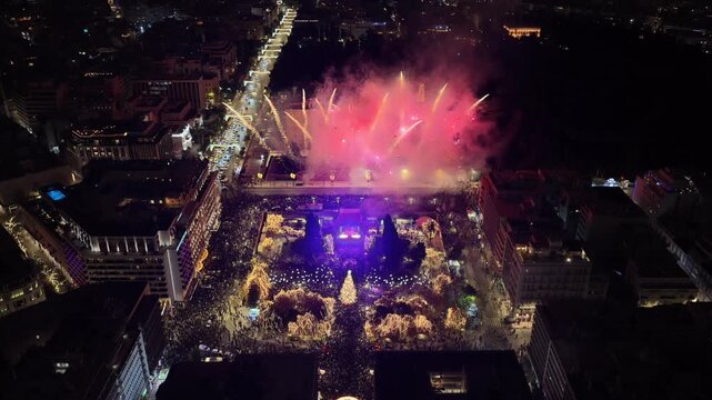 Aerial drone cinematic video of illuminated festive Syntagma square featuring firework show and Christmas tree during New Year's Eve, Athens centre, Attica, Greece