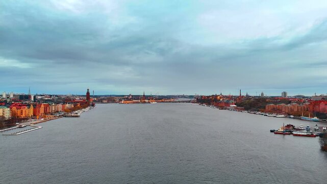 Moving over the grey calm waterscape of Lake Malar. Aerial view on the cityscape of Stockholm, Sweden.