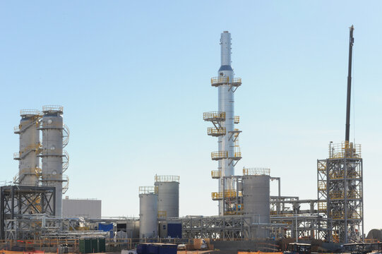 Industrial processing towers and piping infrastructure at a large battery manufacturing plant, representing energy storage production facilities and utility scale industrial operations