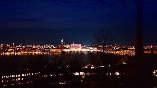 Going up over the waterfront of Lake Malar at night. Revealing view on the cityscape of Stockholm, Sweden.