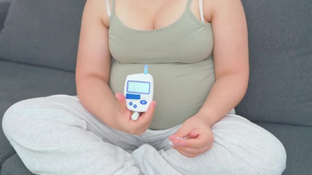 Pregnant woman in her eighth month measuring blood sugar with a portable glucometer. A calm, realistic everyday scene highlighting maternal health, prenatal care, and gestational diabetes management