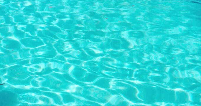 PORTOCOLOM, MALLORCA, SPAIN - OCTOBER, 2025: Close up of water in a pool, ripples and sun reflect on the water's surface, ideal for backgrounds, holidays, and summer themes.