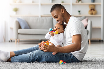 Paternity Time. Loving Young African American Father Playing With His Little Infant Baby At Home,...