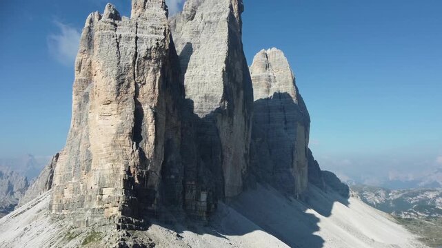 Aerial view of Hiking Trail Three Peaks of Lavaredo. Dramatic aerial view of the Three Peaks of Lavaredo, located in the Dolomites, Italy. The limestone formations rise sharply, with sheer faces