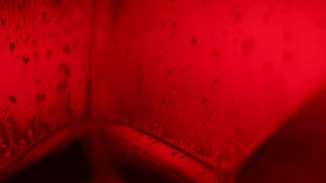 Red psychedelic fluid abstraction, glowing liquid background, bubbles in macro, connection of bubbles in macro, iridescent effect