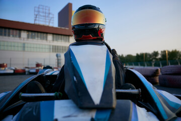 A thrilling view of a go-kart driver gearing up for a race at dusk