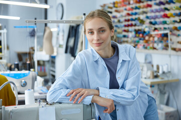 A very creative seamstress is diligently working on her sewing machine in a busy fashion studio