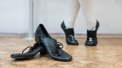 A woman dancing Irish dances. Professional shoes are in the foreground.