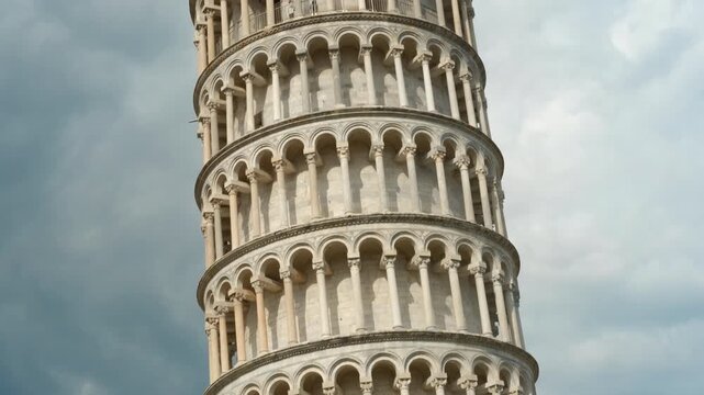 Leaning tower of pisa showing its tilt under cloudy sky. Majestic leaning tower rising against dynamic cloudy sky, highlighting architectural marvel of historic italian landmark