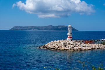 Scenic view of Kaş, with its colorful houses, a small harbor, turquoise waters, and surrounding rocky hills in Antalya, Turkey.