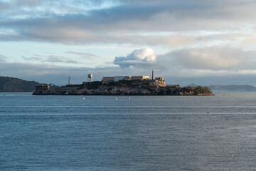 Obraz premium San Francisco, USA - September 10, 2025: Morning view of Alcatraz Island in San Francisco Bay under a cloudy sky, creating a calm, slightly moody atmosphere around the famous former prison.
