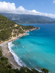 Obraz premium Aerial view of Papaz Koyu(Bay), a secluded Mediterranean cove known for its crystal-clear turquoise water and rocky natural shoreline in Antalya, Turkey.