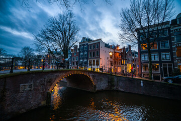 Naklejka premium Enchanting Night Scene of Amsterdams Historic Canal and Bridge