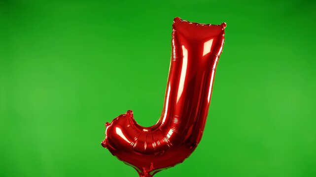 Red Letter J Balloon Floating on Green Screen Background.