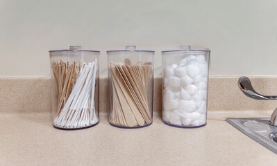 Direct view of containers of cotton balls, tongue depressors and cotton applicators at a medical office