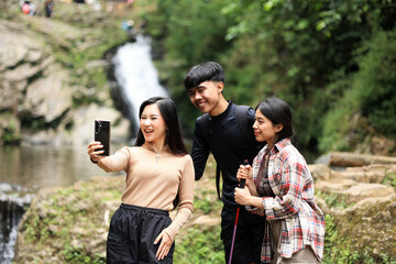 Happy people enjoy and fun outdoor lifestyle using mobile phone taking selfie or vlogging together at forest