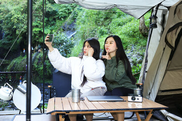 Two Asian Young Female Camper Taking Selfie on Smartphone during Camping&nbsp;