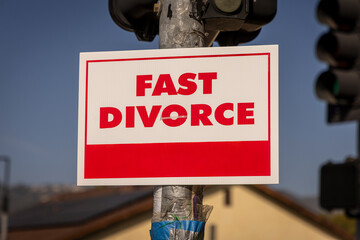 A sign stating Fast Divorce on a light pole in a suburban neighborhood