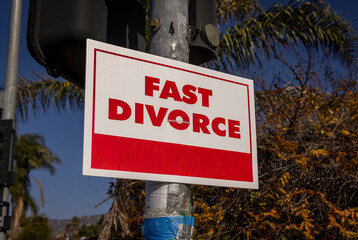 A sign stating Fast Divorce on a light pole in a suburban neighborhood
