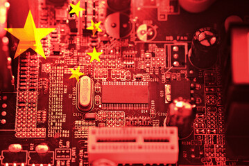 Chinese flag on a computer motherboard with processors. Hardware concept, microelectronics, and trade dispute.