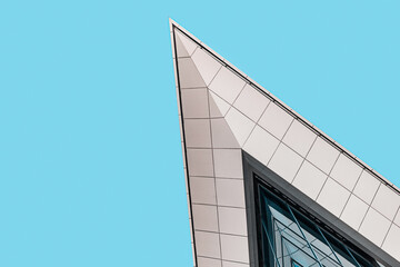 Modern office building against blue sky, low angle view, panorama with free space. Business and real estate background, skyscraper in the financial district