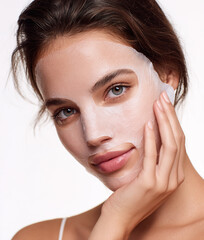 Woman with beauty sheet mask for facial skincare treatment
